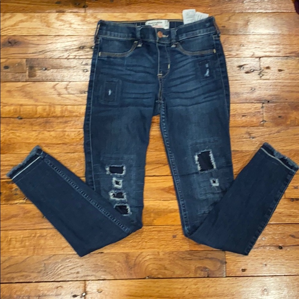 blue denim jeans with small patched rips